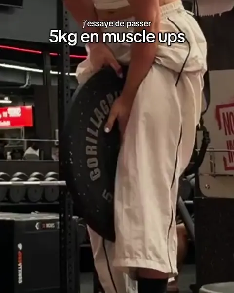 Avril prépare un muscle-up lesté en salle.