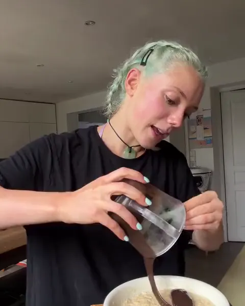 Avril verse un coulis dans sa cuisine.